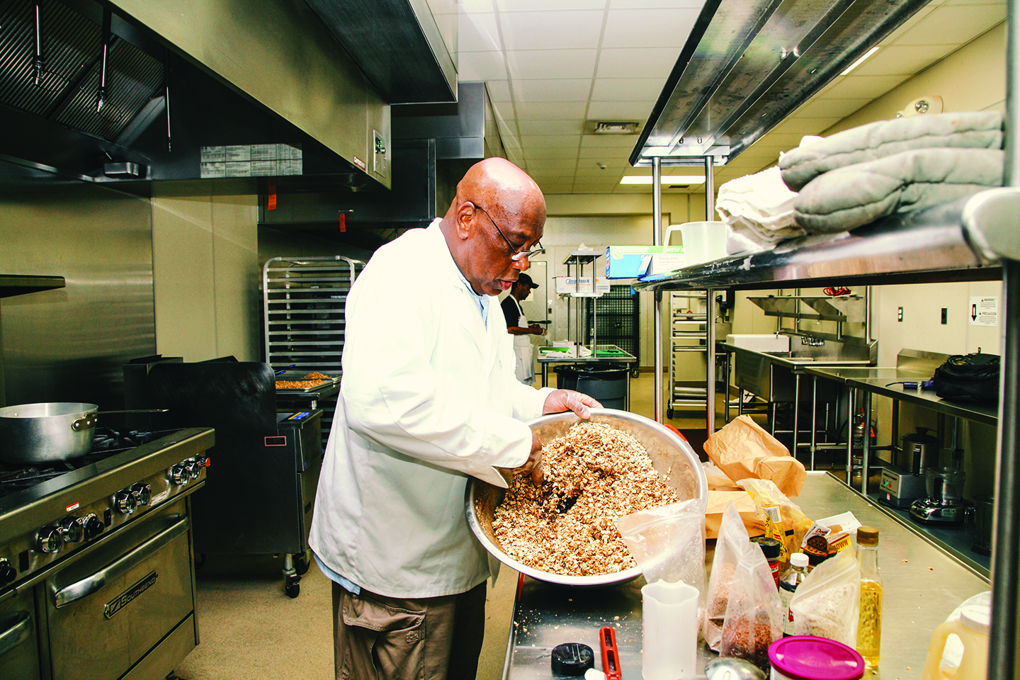 Victor Michael hand-mixes a batch of his&nbsp;Philly Delcious Granola&nbsp;| Photo by Stephen Dyer