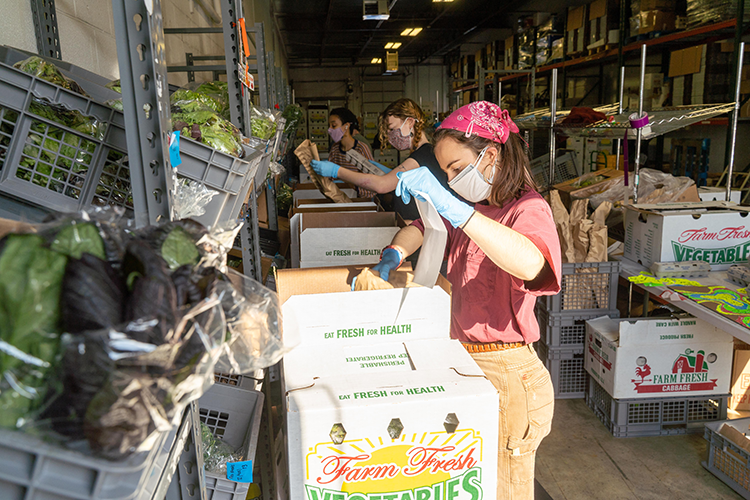 Philly Foodworks employees pack delivery boxes for distribution.