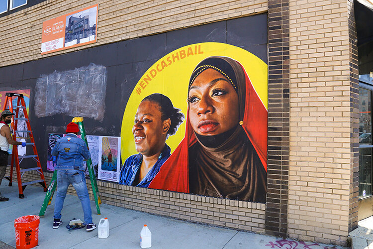mural portrait of two women with "#endcashbail"