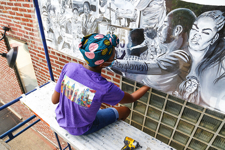 Artist Nilé Livingston with her 2020 Fishtown mural “Entanglement”.