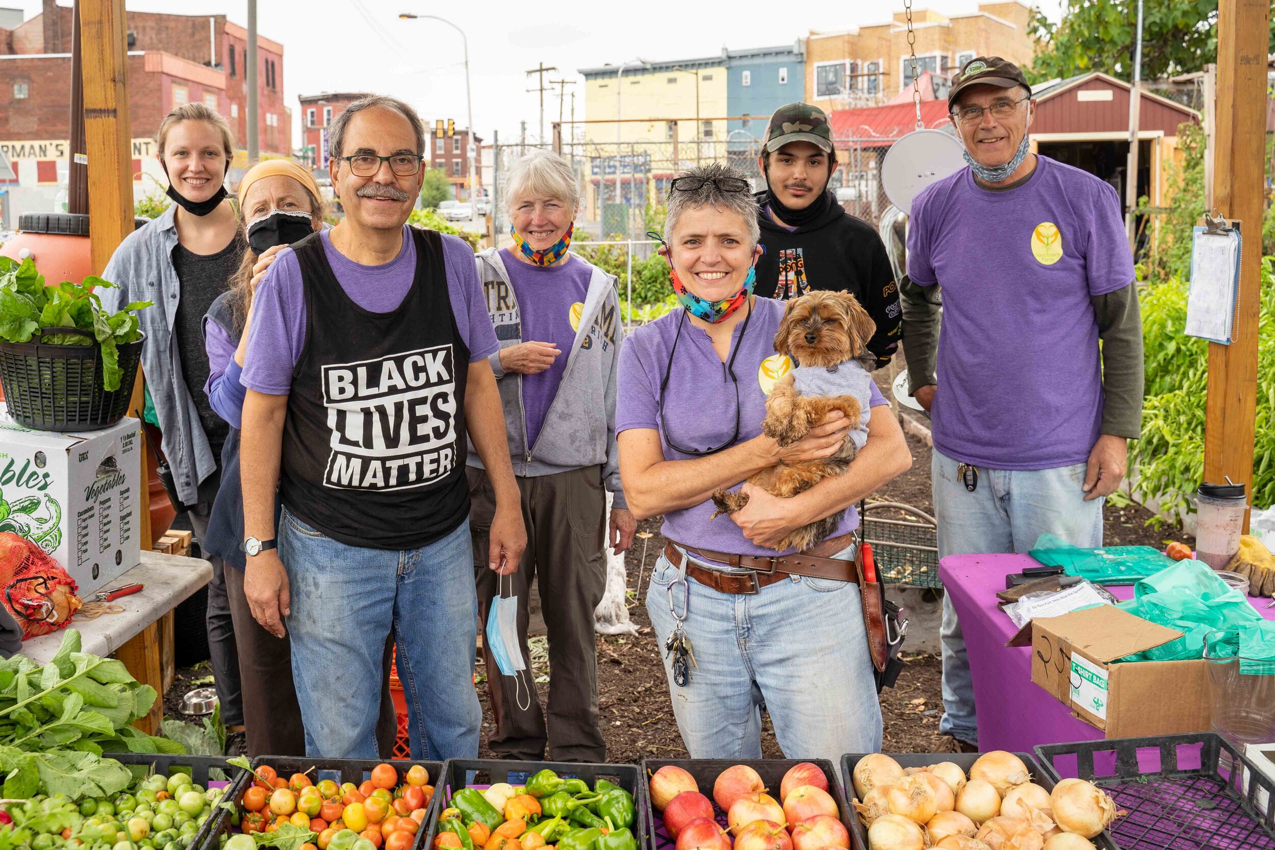 Sanctuary Farm founder Andrea Vettori (with dog) and staff at their produce stand. Photography by Milton Lindsay.