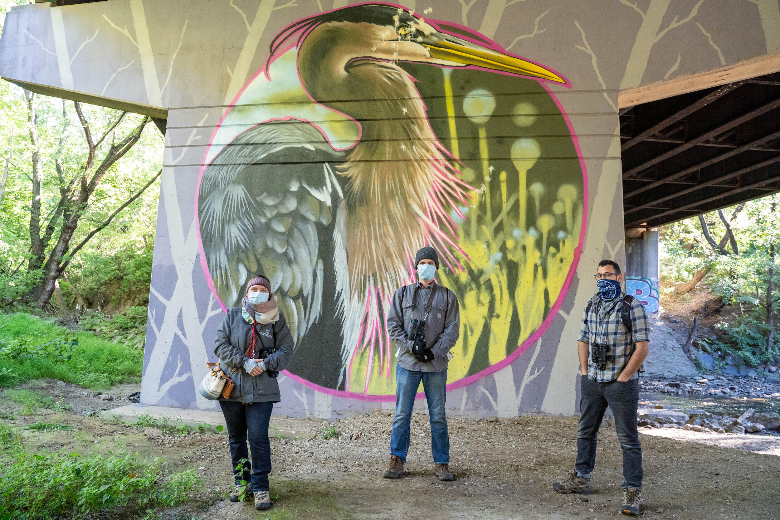 Visitors in front of one of the murals along the trail underneath the Whitaker Bridge. V.U.R.T Creative painted these murals of bird species common to the area.