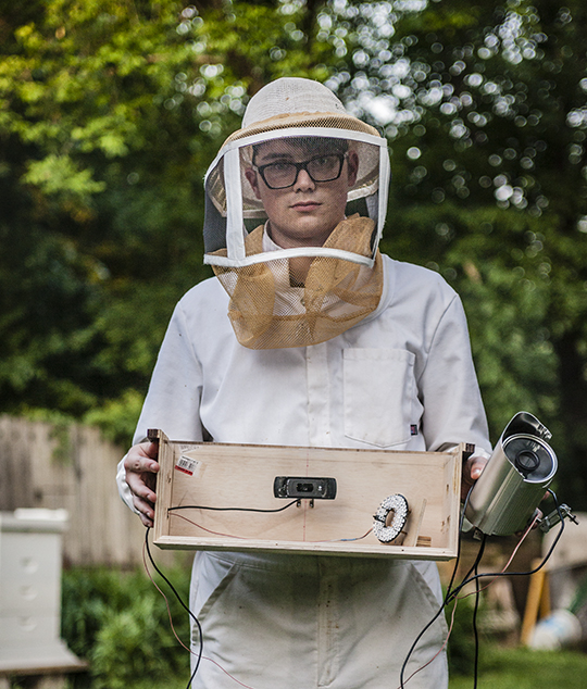 Wynn Geary holds monitoring equipment for his smart beehive. Right: Action in the hive, seen on his laptop, will one day be streamed on a public website |&nbsp;photos by Addison Geary