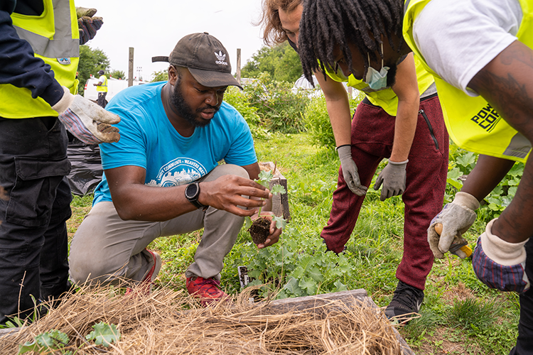 Brandon Ritter of Food Moxie gardens with a group from PowerCorps PHL at Stenton Family Manor. Photography by Milton Lindsay.