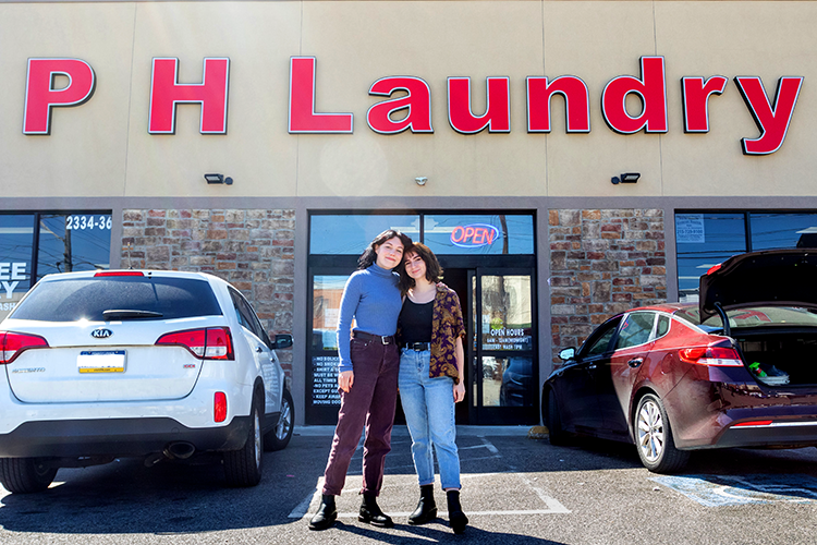 two women standing in laundromat parking lot