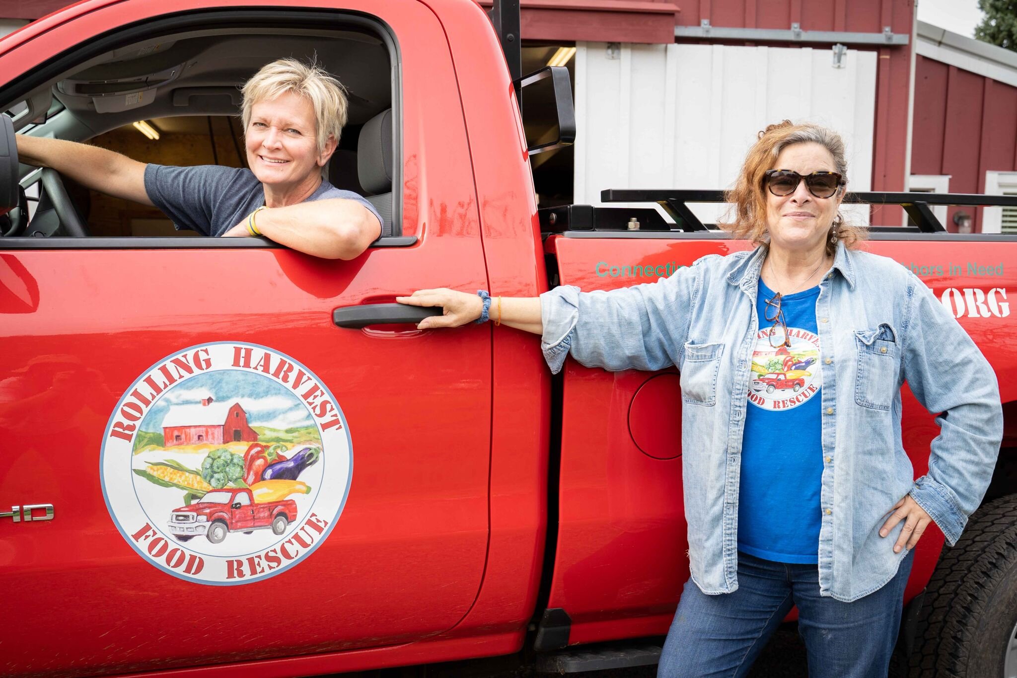 Rolling Harvest program director Jamie McKnight sits in the driver’s seat, posing with founder Cathy Snyder.