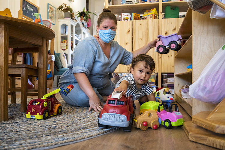 Rutabaga Toy Library founder Krystal Cunillera shows a young client toy options. Photography by Kyle Kielinski.