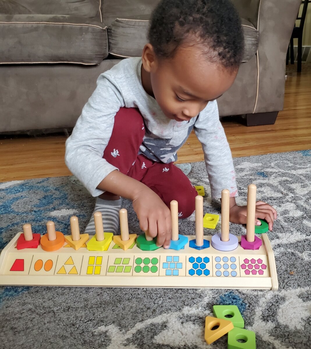 a child playing with a shapes and colors toy
