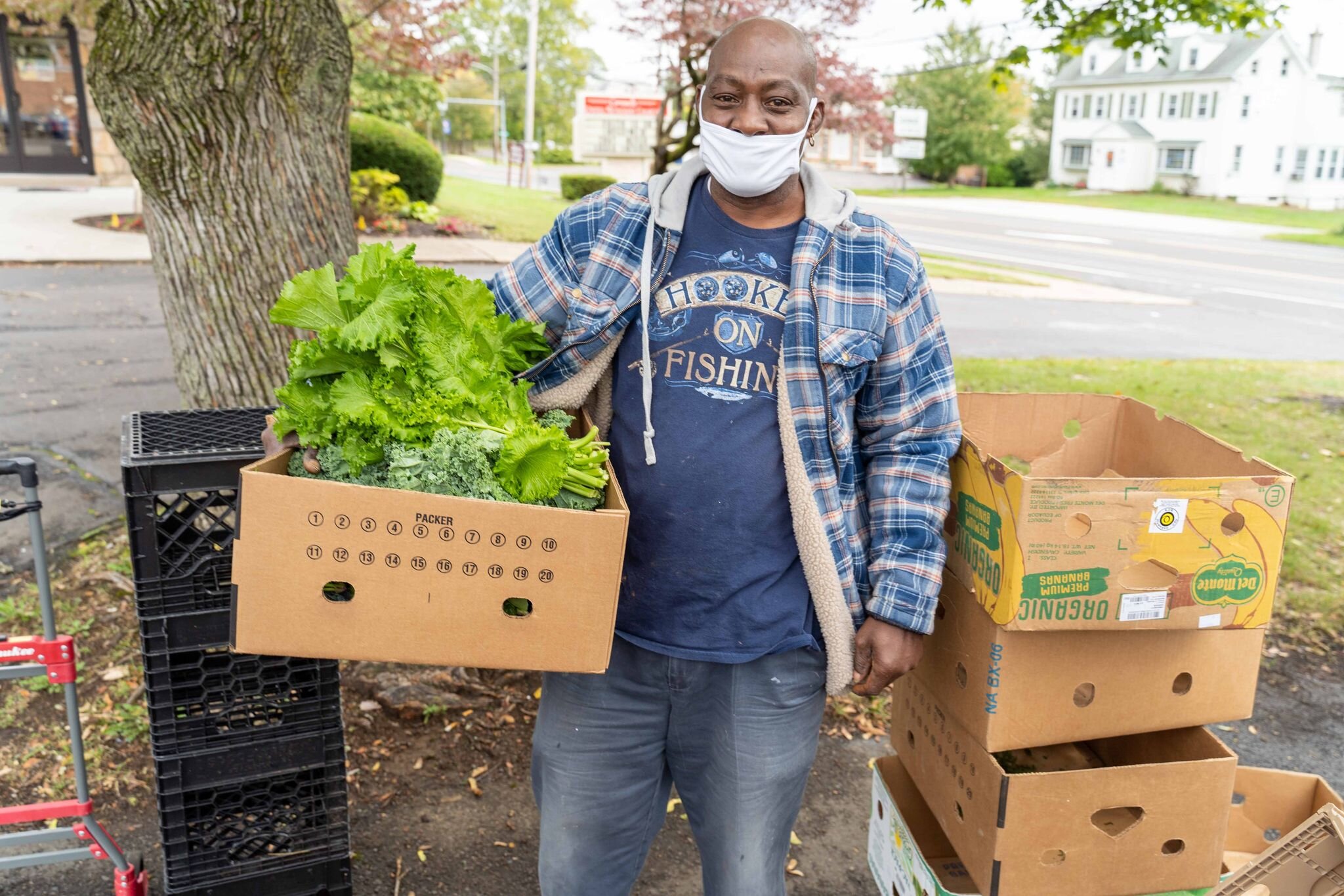 A food pantry volunteer picks up produce from Rolling Harvest.