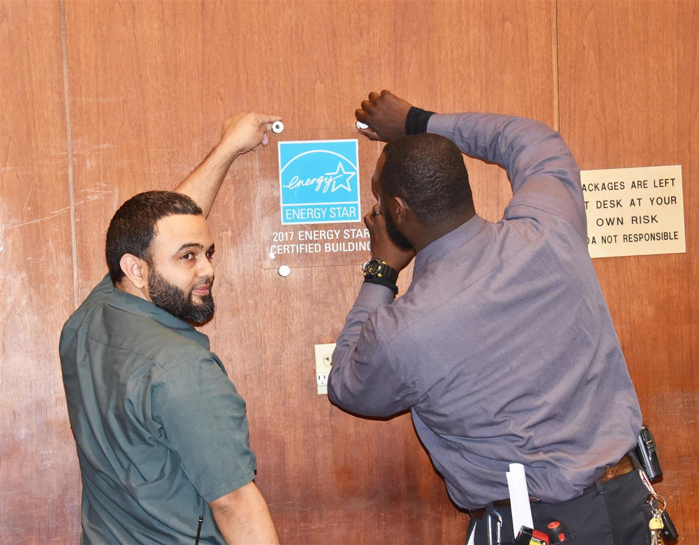 Staff members placing an EnergyStar plaque behind the lobby reception desk at The Philadelphian.Photographs courtesy of Joan Batory.