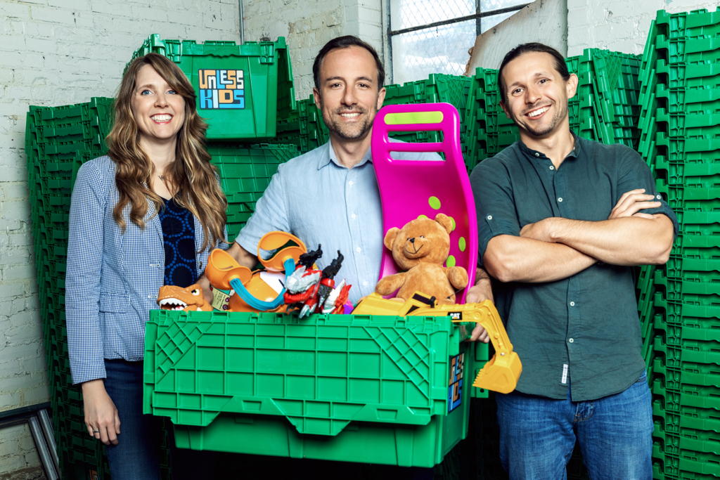 Founders of Unless Kids standing with box of toys